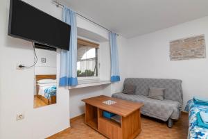 a living room with a couch and a flat screen tv at Studio Basanija 7148a in Savudrija