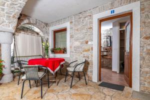 a patio with a red table and chairs on a stone wall at Apartments with WiFi Basanija, Umag - 7148 in Savudrija
