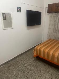 a bedroom with a bed and a flat screen tv on the wall at Business Home in Olivos