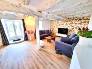 Una sala de estar con dos sofás y un televisor. en Le Cottage 10 personnes, en Aguts