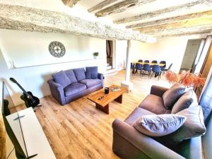 Una sala de estar con dos sofás y una mesa. en Le Cottage 10 personnes, en Aguts