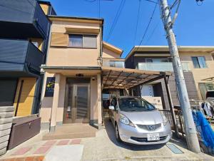 泉佐野市にあるNewOpen, Stella Rinku, りんくうタウン駅徒歩10分, 一棟貸切, 関西空港まで6分の家の前に停められた銀車