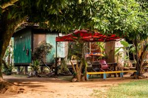 a house with a bench and a red umbrella at Moorea B&B in Motu Tiahura +36 photos