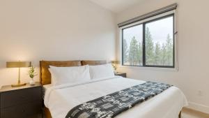 a bedroom with a large bed with a window at Aerie Modern 4 Unit Buyout 4 Units w Hot Tub Mountain Views Near Downtown in Bend