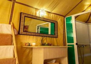 a bathroom with a mirror and a sink in a tent at Berber Luxurious Camp in Merzouga