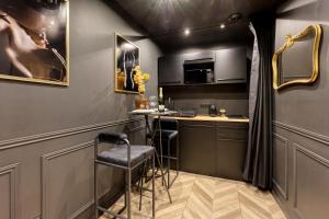 Una pequeña cocina con una barra con taburetes. en BlackLove room, en La Ciotat