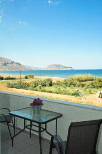 un tavolo e sedie su un balcone con vista sull'oceano di Locanda a Monemvasía