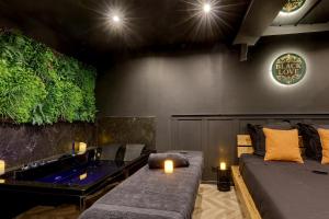 Una sala de estar con bañera, sofá y velas. en BlackLove room, en La Ciotat