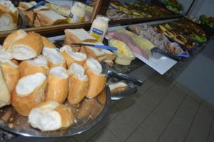 a buffet of sandwiches and other food on plates at Pousada express JK in Foz do Iguaçu
