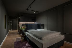 a bedroom with a large bed in a black room at Leipzig Suites in Leipzig