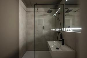 a bathroom with a sink and a glass shower at Leipzig Suites in Leipzig +56 photos