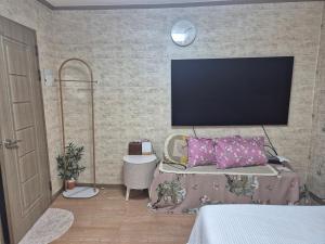 a bedroom with a flat screen tv on a wall at Ara house in Seoul +3 photos