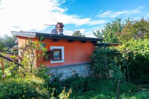 een klein oranje huisje met een raam bovenop bij Holiday house with a parking space Babici, Umag - 13795 in Umag