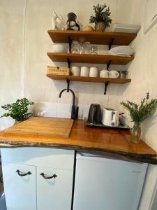 a kitchen with white cabinets and a wooden counter top at Tropical Garden Retreat in Napier +21 photos