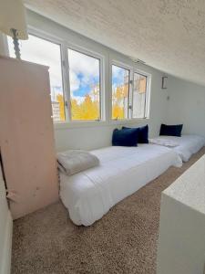 Una habitación con tres camas grandes frente a las ventanas. en Eagles Roost Haven - Cozy Ski View Condo, en Brian Head