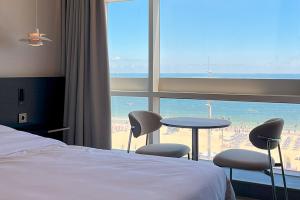 a hotel room with a bed and a view of the beach at 코브스테이 해운대 in Busan