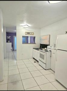 a white kitchen with a stove and a refrigerator at Diversity in San Juan