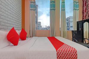 a bedroom with a large bed with red pillows at Hotel O Ki & Kaa in Dānāpur