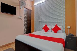 a bedroom with a bed with red pillows and a tv at Hotel O Ki & Kaa in Dānāpur