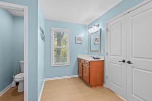 a bathroom with blue walls and a toilet and a sink at New The Breeze at Lake Hartwell house w Dock in Westminster +35 photos