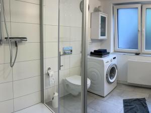 a bathroom with a toilet and a washing machine at Hiltrup Stübchen in Amelsbüren +7 photos
