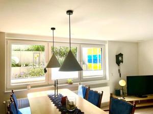 a dining room with a table and two windows at Hiltrup Stübchen in Amelsbüren