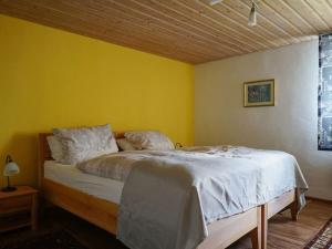 a bedroom with a bed with a yellow wall at One-bedroom apartment in Lalling +34 photos