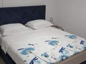 a bed with a blue and white blanket on it at Studio Apartment Sineva in Šibenik