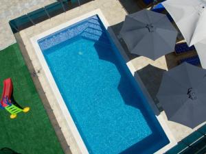 an overhead view of a swimming pool with umbrellas at Holiday Home Marana - Five Bedroom Holiday Home in Čavoglave