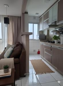 a living room with a couch and a kitchen at Porto dos Açores in Laguna