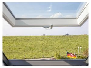 a window with a view of a green field at Holiday apartment with 3 bedrooms in Tossenserdeich