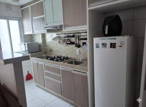 a kitchen with a white refrigerator and a sink at Porto dos Açores in Laguna +8 photos