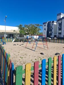 a colorful fence with a playground in the sand at Porto dos Açores in Laguna