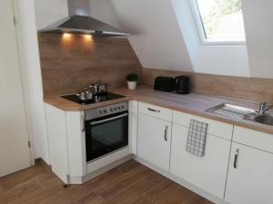 a kitchen with white cabinets and a stove top oven at Holiday apartment in Norden with Wi-Fi in Ekel