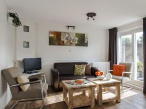 a living room with a couch and a tv at Holiday home in Nes with swimming pool in Nes