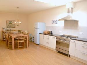 a kitchen with a table and a white refrigerator at with large, fenced garden DL108 in Domburg