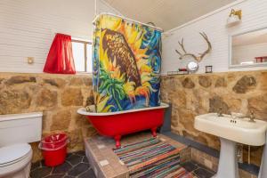 y baño con bañera roja y lavamanos. en Hideaway Cabin cabin, en Rio Frio