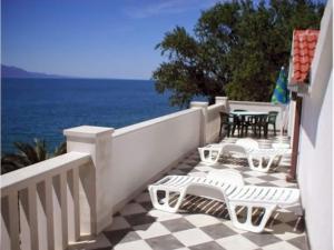 a balcony with white chairs and tables and the ocean at Apartments Pansion Franka 3 - Apartment 1B in Brist