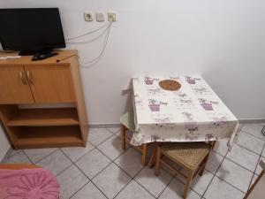 a kitchen with a table and a tv and a table and chairs at Apartments Pansion Franka 3 - Apartment 10 in Brist