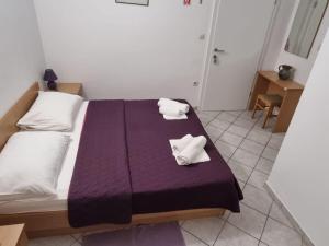 a bedroom with a bed with towels on it at Apartments Pansion Franka 3 - Apartment 10 in Brist