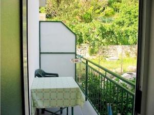 a table and a chair on a balcony at Apartments Pansion Franka 3 - Apartment 10 in Brist