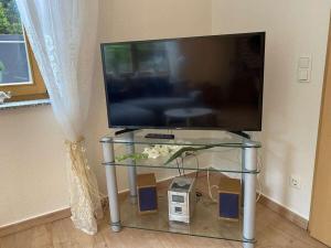 a flat screen tv sitting on a glass table at One-bedroom apartment in Urbar