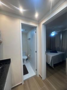 a bathroom with a toilet and a bedroom with a bed at Linkin Home Mapp Rio Branco in Sao Paulo