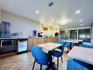 a restaurant with tables and chairs and a kitchen at Sleep Inn & Suites Searcy near University in Searcy
