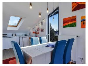 a dining room with a white table and blue chairs at Holiday apartment in Munich with Wi-Fi in Munich