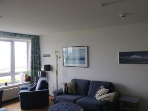 a living room with a blue couch and a window at One-bedroom apartment in Cuxhaven