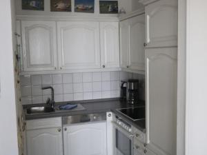 a kitchen with white cabinets and a sink at One-bedroom apartment in Cuxhaven