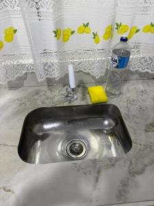 CanoinhasにあるApartamento Bela Vistaの洗剤とシャワーカーテンが備わったキッチンシンク +1枚の写真