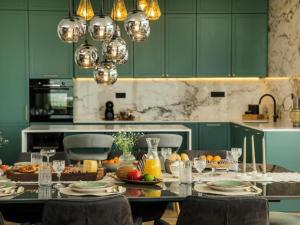 a kitchen with green cabinets and a table with food at Luxury Villa Lara with Heated Pool, Hot-Tub and Sauna - Six Bedroom Villa with Pool in Zmijavci