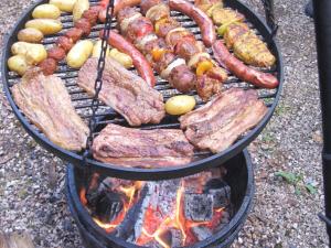 a bunch of meats and vegetables on a grill at Holiday home with 2 bedrooms in Schwollen